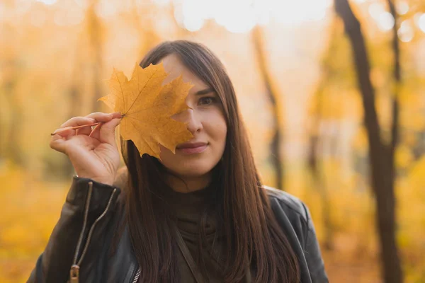 Portret van herfstvrouw met herfstblad op natuurachtergrond. Seizoensconcept. — Stockfoto