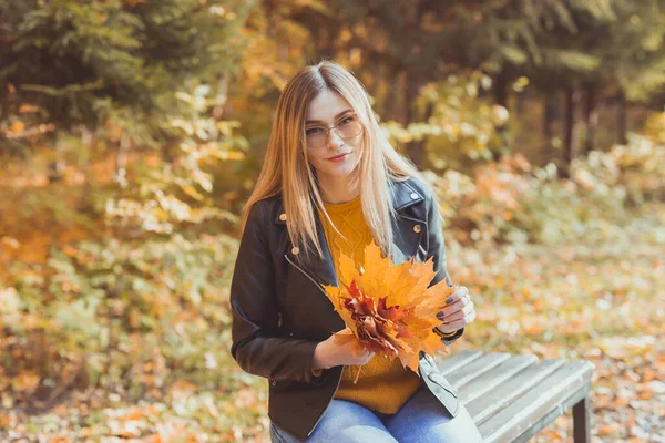 Chica sostiene hojas caídas en el parque de otoño. Concepto estacional. —  Fotos de Stock