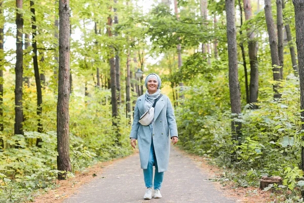Islamitische jonge vrouw draagt hijab staande op herfst park achtergrond. Modern Arabisch moslim meisje. — Stockfoto