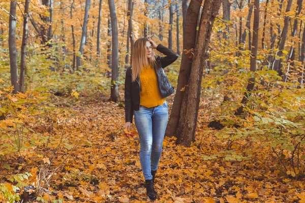 Leuke lachende vrouw met herfstbladeren in het herfstpark. Seizoensgebonden, lifestyle en vrijetijdsconcept. — Stockfoto