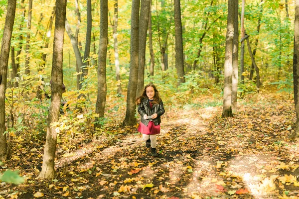 Enfant fille en utilisant un appareil photo à l'ancienne dans la nature d'automne. Photographe, saison d'automne et concept de loisirs. — Photo
