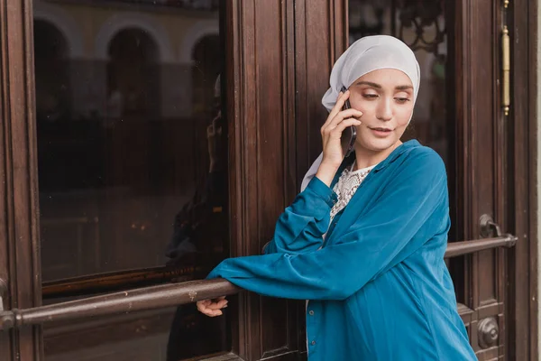 Retrato de jovem asiático muçulmano estudante mulher falando no celular ao ar livre — Fotografia de Stock