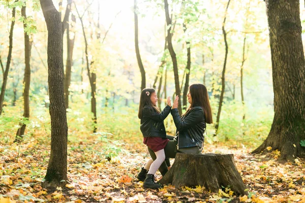 Mãe e filha passam o tempo juntos no outono parque amarelo. Temporada e conceito de pai único. — Fotografia de Stock