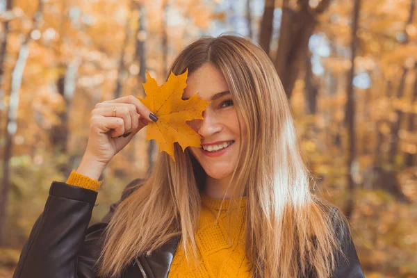 秋天枫叶覆盖秋天背景的年轻女子 — 图库照片
