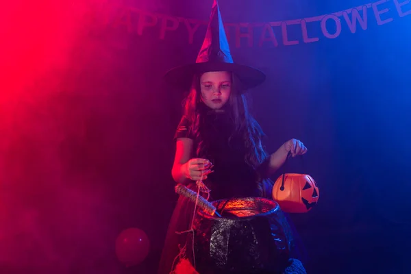 Petite sorcière enfant cuisson potion dans le chaudron sur Halloween. — Photo