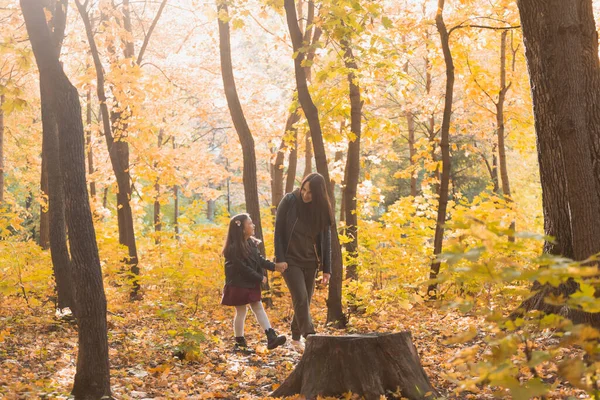 Молодая женщина и ее девочка прогуливаются по осеннему парку. Концепция одиноких родителей и материнства. — стоковое фото