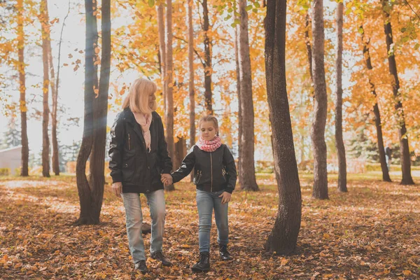 Abuela con nieta en el parque de otoño. Generación y concepto familiar. —  Fotos de Stock
