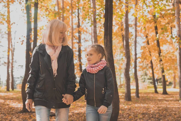 Abuela con nieta en el parque de otoño. Generación y concepto familiar. —  Fotos de Stock