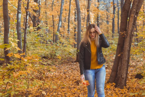 Cute smiley kobieta trzyma jesienne liście w jesiennym parku. Koncepcja sezonowości, stylu życia i wypoczynku. — Zdjęcie stockowe