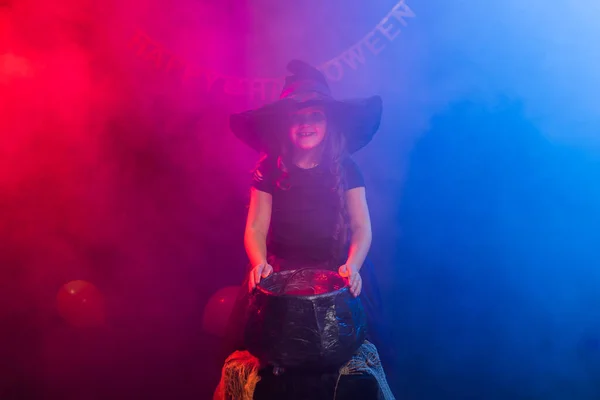 Hexenkind bereitet an den Halloween-Feiertagen einen Zaubertrank im Hexenkessel zu. — Stockfoto