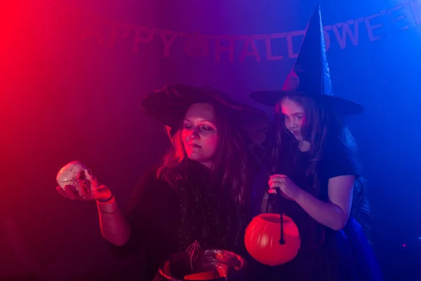 ハロウィーンの夜に2人の魔女がポーションを作り、陽気。魔法、休日や神秘的な概念. — ストック写真