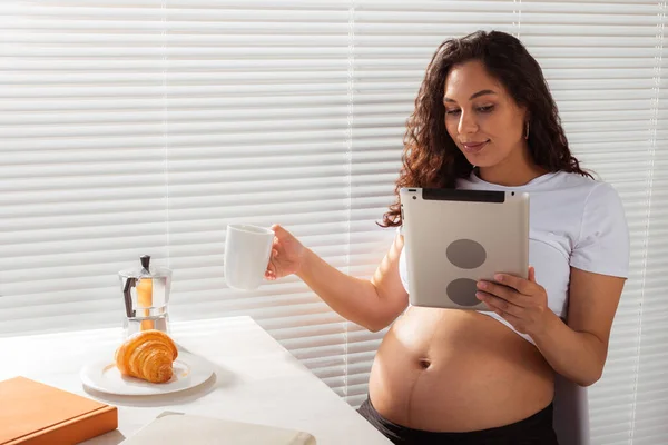怀孕妇女使用数码平板电脑。早餐时间。技术和怀孕概念. — 图库照片