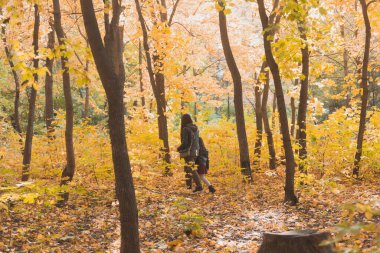 Anne ve küçük kızı sonbahar parkında sonbahar mevsiminde.