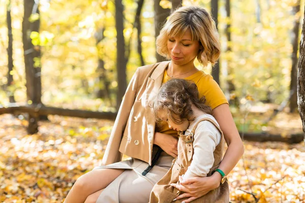 Jonge moeder met haar dochtertje in een herfstpark. Herfstseizoen, ouderschap en kinderconcept. — Stockfoto