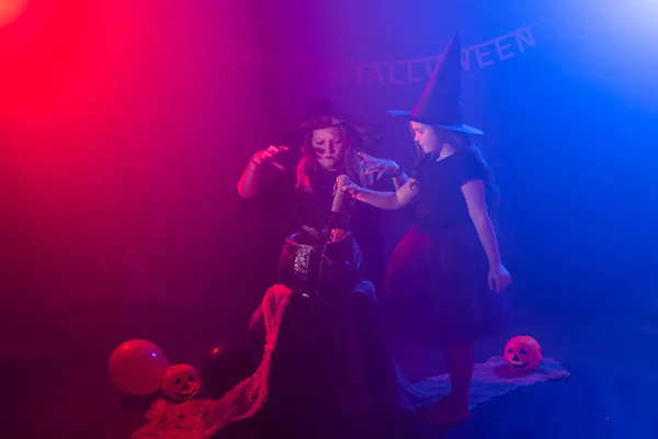 Zwei Halloween-Hexen basteln einen Zaubertrank und zaubern in der Halloween-Nacht. Magie, Urlaub und mystisches Konzept. — Stockfoto