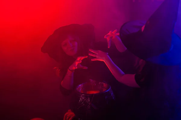 有趣的小女孩和穿着巫婆服装的女人在万圣节制造魔法. — 图库照片