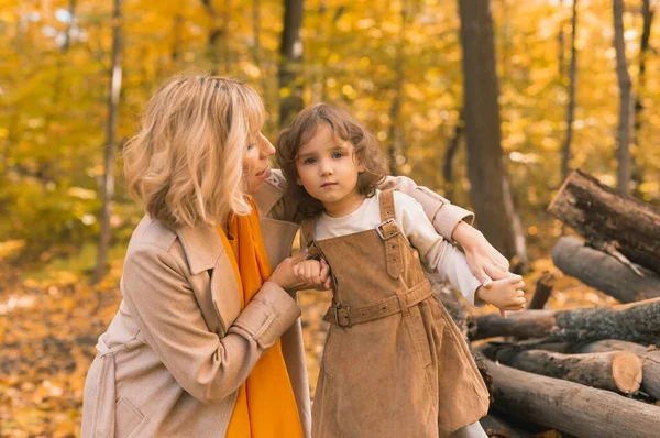 Madre joven con su hija pequeña en un parque de otoño. Temporada de otoño, crianza y concepto de hijos. —  Fotos de Stock