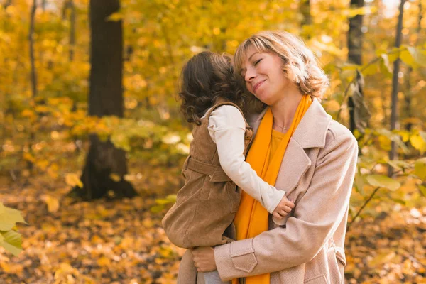 Madre joven con su hija pequeña en un parque de otoño. Temporada de otoño, crianza y concepto de hijos. —  Fotos de Stock