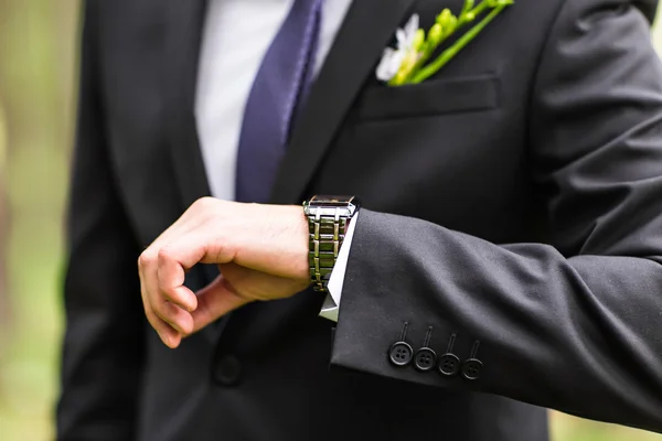 Giovane uomo d'affari guardando orologio su sfondo bianco — Foto Stock