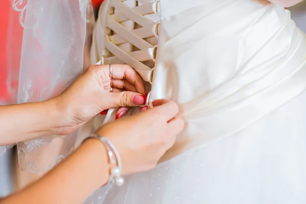 Brautjungfer hilft der Braut, sich zu kleiden — Stockfoto