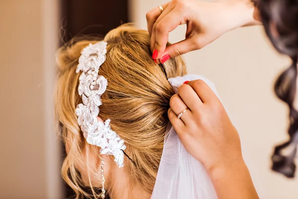 Stylist makes wedding hairstyle