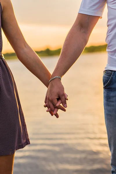 Счастливая пара держит закат за руку — стоковое фото