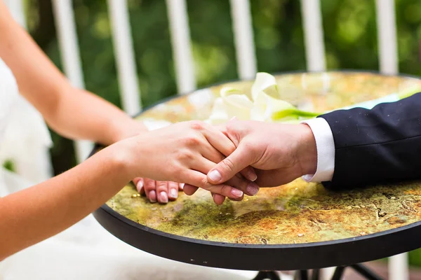 Bröllopspar som håller varandra i handen — Stockfoto