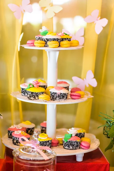 Table de dessert pour une fête. Gâteau ombre, cupcakes, douceur et fleurs — Photo