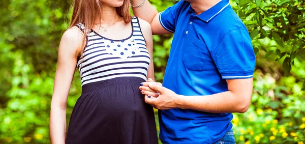 Беременная женщина и ее муж в парке — стоковое фото