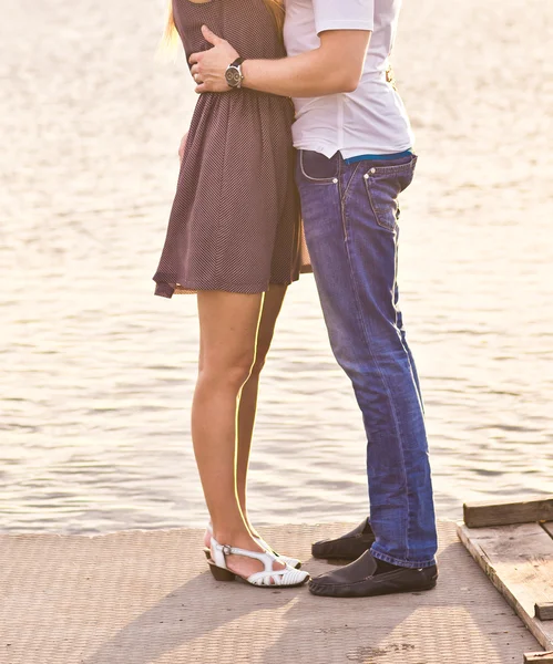 Happy couple hugging while standing on the bank of a river — Stock Photo, Image