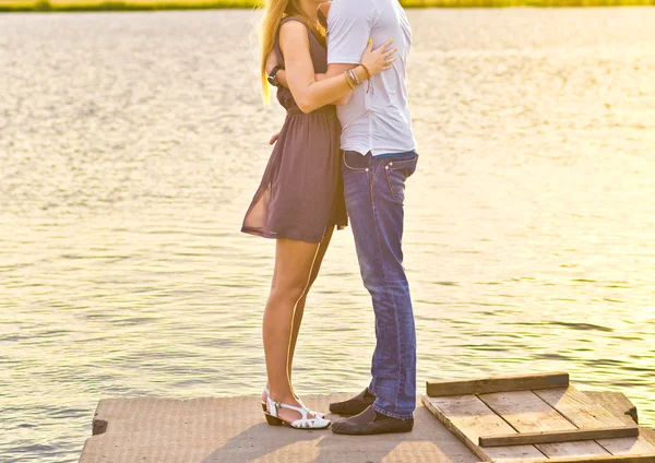 Mutlu çifte bir nehir kıyısında dururken sarılma 