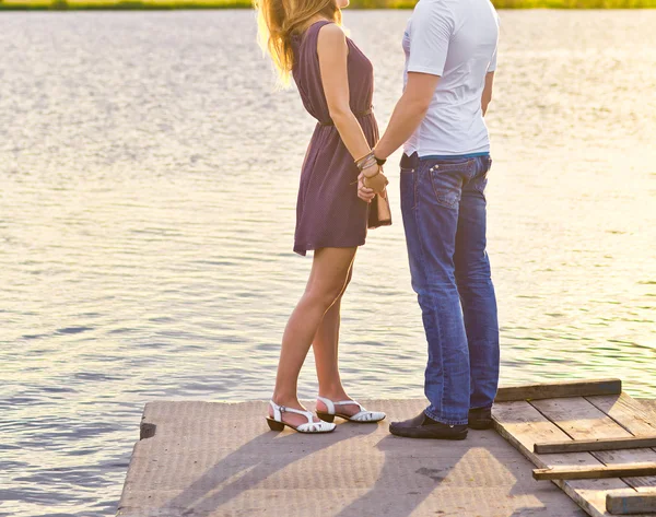 Happy couple hugging while standing on the bank of a river — Stock Photo, Image