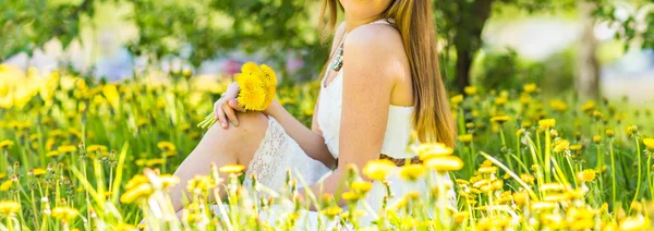 Young woman which sits on green grass — Stock Photo, Image