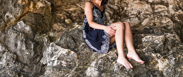 Menina sentado em uma caverna de pedra — Fotografia de Stock