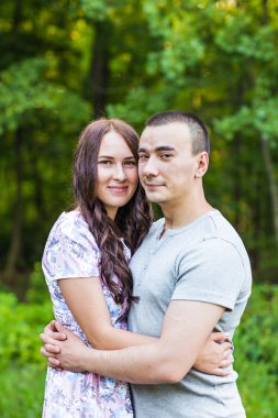 Çift bir parkta rahatlatıcı gülümseyen. 