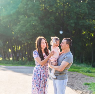 Parkta yürüyen mutlu bir aile..