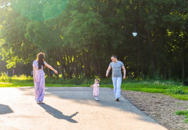 Parkta yürüyen mutlu bir aile..