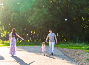 Parkta yürüyen mutlu bir aile..
