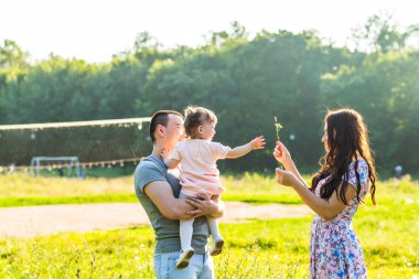 Parkta yürüyen mutlu bir aile..
