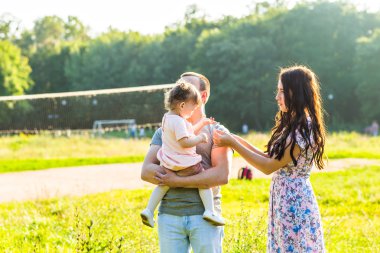 Parkta yürüyen mutlu bir aile..