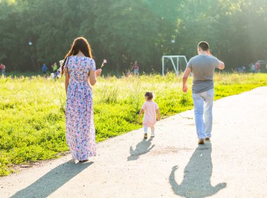 Parkta yürüyen mutlu bir aile..