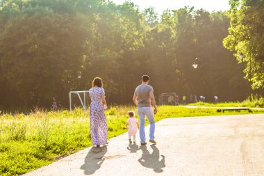 Parkta yürüyen mutlu bir aile..