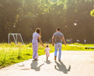 Parkta yürüyen mutlu bir aile..