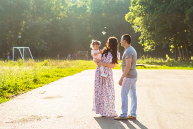 Parkta yürüyen mutlu bir aile..