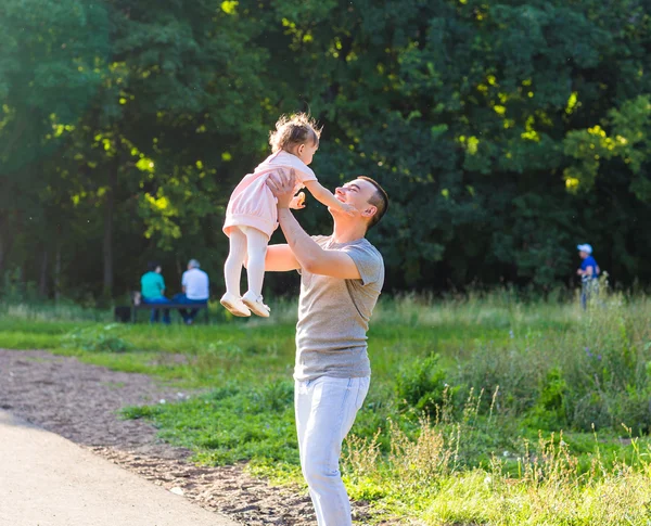 Baby girl walking in a summer park with her father — Stock Photo, Image