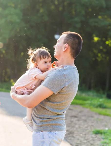 Bébé fille marche dans un parc d'été avec son père — Photo