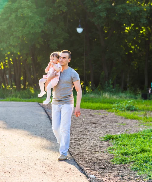 Baby flicka vandrar i en sommar park med sin far — Stockfoto
