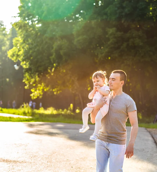 Bebé niña caminando en un parque de verano con su padre — Foto de Stock