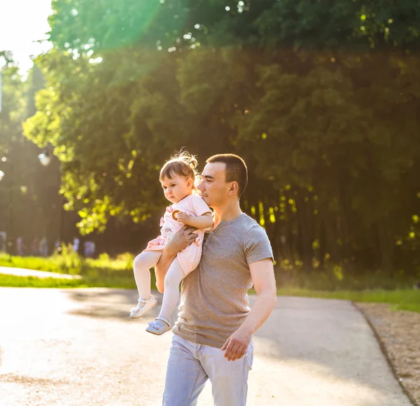 Bambina che cammina in un parco estivo con suo padre — Foto Stock