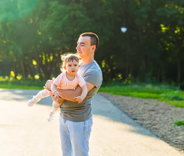 Bébé fille marche dans un parc d'été avec son père — Photo